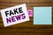 Handwriting Announcement text showing Fake News. Business concept for Hoax Journalism written on sticky note paper on wooden backg