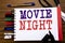 Handwriting Announcement text showing Movie Night. Business concept for Wathing Movies Written on notebook, wooden background wit