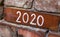 Handwriting text 2020 on old red city bricks wall