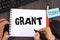 Handwriting text Grant. Concept meaning Money given by an organization or government for a purpose Scholarship written by Man on N