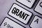 Handwriting text Grant. Concept meaning Money given by an organization or government for a purpose Scholarship written on the Whit