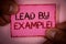 Handwriting text Lead By Example Motivational Call. Concept meaning Leadership Management Mentor Organization Words written pink p