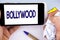 Handwriting text writing Bollywood. Concept meaning Indian cinema a source of entertainment written on Mobile Phone Screen holding