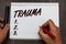 Handwriting text writing Trauma. Concept meaning Disturbing physical and emotional injuries shock experience Graph paper thoughts