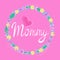 Handwritten lettering with word mommy and pink heart inside a floral wreath. Isolated vector illustration.