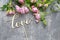 Handwritten love word and pink roses on grey stone background