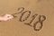 Handwritten numbers on the sand 2018 with male hand