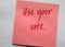 Handwritten red letters on plain background `Use your vote`