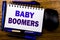 Handwritten text showing Baby Boomers. Business concept for Demographic Generation written on notebook book note paper on the wood