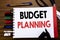 Handwritten text showing Budget Planning. Business concept for Financial Budgeting Written on notebook, wooden background with off