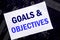 Handwritten text showing Goals Objectives. Business concept for Plan Success Vision Written on sticky note, computer main board ba