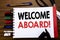 Handwritten text showing Welcome Aboard. Business concept for Greeting Join Member Written on notebook, wooden background with off