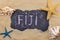 Handwritten word FIJI written in chalk, among seashells and starfishes