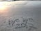 Handwritten words â€œbye bye 2017â€ on the beach with many footprints
