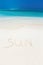Handwritting inscription word SUN on sandy beach