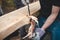 Handy woodcutter prepares larch wood for later processing. Planing wood. Working larch boards with traditional tools. Hand