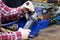 A handyman with angular grinding machine. Men`s hands holding an angular grinding machine. A locksmith vise