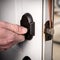 Handyman applies a drop of lubricating oil on the deadbolt of a garage door