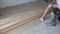 Handyman apply glue adhesive on concrete floor. Worker install wooden floor