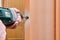 Handyman drills hole for latch of door knob