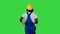 Handyman man in protective helmet hold wallpaper rolls walking and pointing with a brush to the sides on a Green Screen