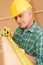 Handyman mature carpenter measure wooden beam