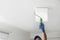 Handyman painting ceiling with white dye, closeup. Space for text