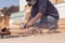 A handyman polishing wooden plank outdoor