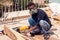 A handyman polishing wooden plank outdoor