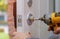 handyman repair the door lock in worker& x27;s hands installing new door locker