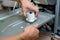 Handyman repairs dishwasher with screwdriver
