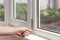 Handyman repairs plastic window with a hexagon. Workman adjusts the operation of the plastic window