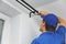 Handyman services - worker installing window curtain rod on the wall