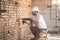 Handyman uses jackhammer, for installation, professional worker on the construction site. The concept of electrician and handyman