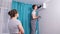 Handyman wearing workwear repairs air conditioner in room