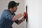 Handyman worker with putty knife working on apartment wall filling