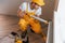 Handyman in yellow uniform works indoors with heat battery by using special tool. House renovation conception