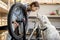 Handywoman with dog reparing bicycle in the workshop