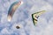 Hang glider and Para glider in fight off on cloudy sky