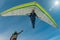 Hang glider pilot gives high five to his friend standing on the ground