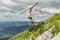 Hang glider pilots runs from steep slope high in the mountains in Uchka, Croatia