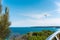 Hang glider soaring over a tranquil azure sea on a clear, sunny summer day