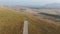 Hang gliders take off from the runway in the mountains above the valley with a dried lake and vineyards