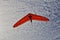 Hang gliding man on an orange wing in the sky