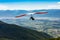 Hang gliding over valley farmlands and mountains