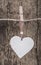 Hanged white heart against wooden background