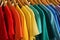 Hangers with bright clothes as background. Rainbow colors