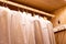 Hangers with different clothes in wardrobe closet.shirts and dress hanging on rail in wooden wardrobe. minimalistic