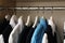 Hangers with teenage clothes on rack in wardrobe