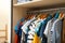 Hangers with teenage clothes on rack in wardrobe